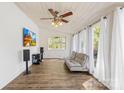 Bright sunroom with hardwood floors, white paneled walls, and large windows with white curtains at 4375 Creek Ave, Midland, NC 28107