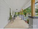 Spacious covered front porch with seating, columns, and hanging plants at 481 Union Cemetery Sw Rd, Concord, NC 28027