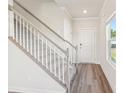 Bright entryway showcasing the staircase with gray carpet, accompanied by wood-look floors and a white front door at 5016 Poplin Vly, Cherryville, NC 28021