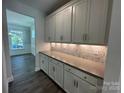 Elegant butler's pantry featuring white cabinets, decorative backsplash, and sleek countertops at 5100 Verona Rd # 96, Charlotte, NC 28213