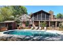 A backyard pool with lounge chairs sits near a charming home with a screened porch at 7424 Windy Pine Cir, Denver, NC 28037