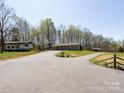 Long paved driveway leading to a cozy, single-story home with an RV, a storage building and a deer ornament at 7545 Brancy St, Kannapolis, NC 28081