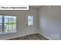 Bright entryway with wood-look flooring, a decorative glass door, and large window at 8067 Kennesaw Dr, Gastonia, NC 28056