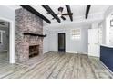 Spacious living room features a brick fireplace, ceiling beams, and light wood floors at 105 Deaver St, Chester, SC 29706