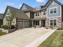 Beautiful two-story home with stone accents, a well-manicured lawn, and a spacious driveway at 10904 Kilkenny Dr, Matthews, NC 28105