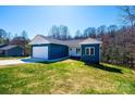 Beautiful blue single-story home with white trim, set on a large, grassy lot with trees in the background at 1314 39Th Street Sw Cir, Hickory, NC 28602