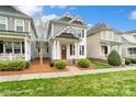 This home has gray siding, a well manicured lawn, and beautiful architectural details at 13712 Bonnerby Ct, Huntersville, NC 28078