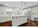 Bright, white kitchen with stainless steel appliances, pendant lighting, and dark hardwood floors at 13712 Bonnerby Ct, Huntersville, NC 28078