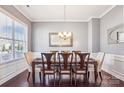Elegant dining room featuring hardwood floors, crown molding, and a stylish chandelier above table at 15402 Country Lake Dr, Pineville, NC 28134