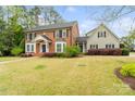 A beautiful brick home with a well-maintained lawn, complemented by lush landscaping and a connecting side house at 1736 Cavendale Dr, Rock Hill, SC 29732