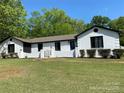 Inviting painted brick home features a bright blue front door, lush lawn, and manicured landscaping under a clear blue sky at 1946 Fairway Dr, Lancaster, SC 29720