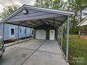 Spacious carport with a concrete floor, metal beams, and a separate storage area with a roll-up door at 2021 Hilton Way Rd, Lancaster, SC 29720
