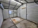 Inside the storage building in the carport, you can see a concrete floor and metal siding walls at 2021 Hilton Way Rd, Lancaster, SC 29720