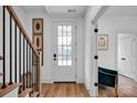 Bright entryway featuring a glass paneled door, hardwood floors, and staircase with black metal railing at 221 Davidson Gateway Dr, Davidson, NC 28036