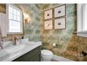 Stylish powder room showcasing decorative wallpaper, framed artwork, and a modern vanity at 221 Davidson Gateway Dr, Davidson, NC 28036