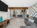 Open-concept living room featuring a cozy sitting area connected to a modern kitchen with stainless appliances at 2633 N Sharon Amity Rd, Charlotte, NC 28205