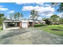 Inviting brick home with attached garage and carport, complemented by green lawn and mature trees at 3017 Lynwood Dr, Lancaster, SC 29720