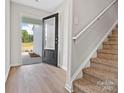 Bright foyer with wood-look floors, a staircase, and an open door leading to the exterior at 3034 Trailblazer St, Charlotte, NC 28215