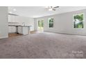 Spacious living room with carpet, large windows, and an open floor plan to the kitchen at 3034 Trailblazer St, Charlotte, NC 28215