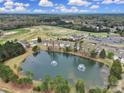 Scenic aerial view showcasing townhomes, a lake with fountains, a golf course, and lush greenery at 44455 Oriole Dr # 100, Indian Land, SC 29707