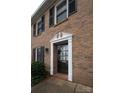 Close-up of a brick home's front door, showcasing its classic white trim and inviting entrance, set against the textured brick at 4609 Hedgemore Dr # I, Charlotte, NC 28209