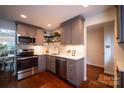 Updated kitchen features stainless appliances, grey cabinetry, quartz countertops, and stylish backsplash, creating a modern and functional space at 4609 Hedgemore Dr # I, Charlotte, NC 28209