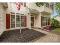 Charming two-story home featuring vinyl siding, red shutters, landscaped yard, and a welcoming front entrance at 5519 Burning Ridge Dr, Monroe, NC 28110