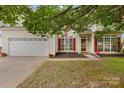 Charming two-story home with white siding, red shutters, and an attached two-car garage at 5519 Burning Ridge Dr, Monroe, NC 28110