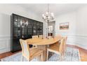 Formal dining area featuring modern lighting, a unique table, and a display cabinet at 6312 Crosshall Pl, Waxhaw, NC 28173