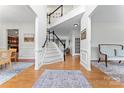 Bright foyer with wood floors, staircase, and classic architectural details at 6312 Crosshall Pl, Waxhaw, NC 28173