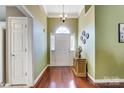 Bright foyer featuring hardwood floors, a chandelier, and a view of the front door with sidelights at 6420 Conifer Cir, Indian Trail, NC 28079