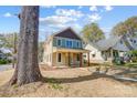 Attractive two-story home with a covered front porch nestled among mature trees in a residential area at 68 Cabarrus W Ave, Concord, NC 28025