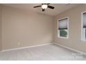 Bright bedroom featuring neutral walls, carpet flooring, a ceiling fan, and a window at 7217 Cedarfield Rd, Charlotte, NC 28227