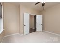 Bright bedroom featuring neutral walls, carpet flooring, and a double-door entry at 7217 Cedarfield Rd, Charlotte, NC 28227
