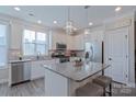 Modern kitchen featuring stainless steel appliances, a granite island, and stylish pendant lighting at 119 Capital Ave # E, Mooresville, NC 28117