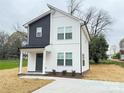 Charming two-story home with white siding, dark accents, and a welcoming front porch at 1406 Mason St, Kannapolis, NC 28081