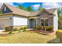 Detailed view of stone accents and landscaping enhance the curb appeal of this charming home at 1625 Carolina Orchards Blvd, Fort Mill, SC 29715