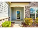 Inviting front porch featuring stone accents and a glass front door, surrounded by manicured landscaping at 1625 Carolina Orchards Blvd, Fort Mill, SC 29715