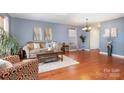 Inviting living room with hardwood floors, soft blue walls, and cozy seating arrangements at 2005 Dunsmore Ln, Waxhaw, NC 28173