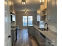 Stylish kitchen featuring gray cabinets, granite countertops, and stainless steel appliances at 2006 Cramerton Village Dr # 31-D, Cramerton, NC 28032