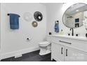 Modern bathroom featuring a sleek vanity, black fixtures, decorative wall art, and stylish black tile flooring at 2038 Sandhurst Dr, Charlotte, NC 28205