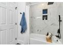Newly renovated bathroom with a shower-tub combination featuring modern tile, black fixtures, and a decorative plant at 2038 Sandhurst Dr, Charlotte, NC 28205