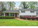Traditional home featuring manicured landscaping, a brick facade, and white siding at 205 Gamble Ave, Bessemer City, NC 28016