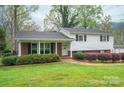 Traditional home featuring manicured landscaping, a brick facade, and white siding at 205 Gamble Ave, Bessemer City, NC 28016