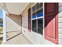 Covered porch with support columns and views of the window and red door creating an inviting entryway at 213 Morton St, Shelby, NC 28152