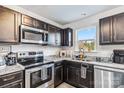 Modern kitchen featuring stainless steel appliances, dark cabinets, granite countertops, and a window providing natural light at 213 Morton St, Shelby, NC 28152