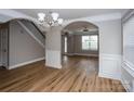 Open-concept living room with elegant chandelier, hardwood floors, and natural light at 240 Bluffton Rd, Mooresville, NC 28115