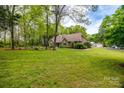 Well-manicured lawn and landscaped front yard lead to a charming brick home with a long driveway at 2470 Highway 557 Rd, Clover, SC 29710