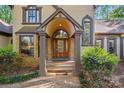 A grand entrance with stone pillars, arched doorway and natural wood door create an impressive facade at 252 Greyfriars Rd, Mooresville, NC 28117