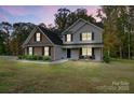 Two-story home with brick and siding, black shutters, and a well-manicured lawn at dusk at 3018 Corinth Church Rd, Monroe, NC 28112